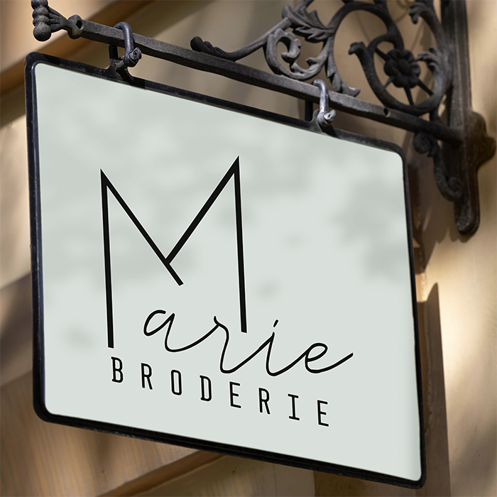 Deurhangbord met het logo van Marie Broderie.