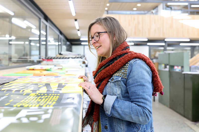 Anne die naar drukwerk aan het kijken is bij een bezoek aan haar oude school kunstkaai.